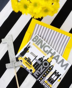 a black and white striped table cloth with yellow flowers in the background, including a card that says bricham no more