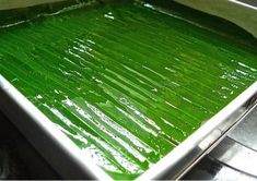 a pan filled with green food sitting on top of a stove