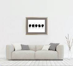 a living room with a white couch and framed art on the wall above it is an image of three women's silhouettes