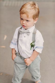 a young boy wearing a bow tie and suspenders