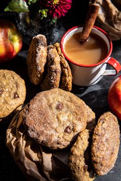 some cookies and apples are next to a cup of coffee