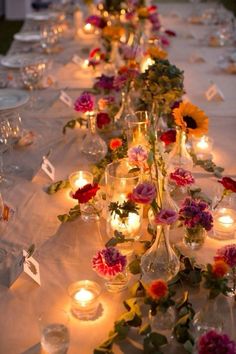 a long table with candles and flowers on it