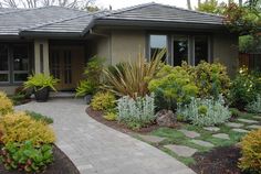 a house with landscaping in the front yard and walkway leading up to it's entrance