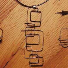 three pieces of wire sitting on top of a wooden table