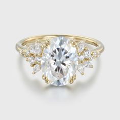 a yellow gold engagement ring with an oval cut diamond surrounded by small white diamonds