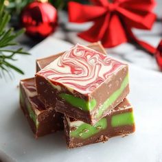 three pieces of candy sitting on top of a white cutting board next to christmas decorations