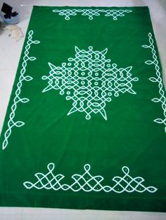 a green rug with white designs on it