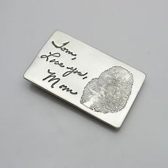 a silver money clip that says i love you to the moon and back with a fingerprint on it