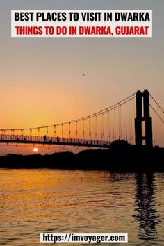 the sun is setting behind a bridge with people walking across it in front of water