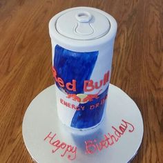 a birthday cake made to look like a can of red bull energy drink on a plate