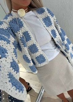 a woman wearing a blue and white crocheted jacket