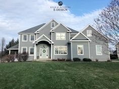 a gray house sitting on top of a lush green field