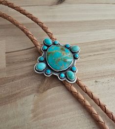 "I have used 925 sterling silver for this amazing piece.  I have chosen some amazing genuine turquoise.  The focal stone is a natural Royston.  And I have surrounded it with Campitos and Kingman turquoise.  I have shaped this for a unique appeal.  Then added patina to excentuate the gorgeous colors.  I have chosen a beautiful natural color for the leather.   And added a tension bolo clasp for ease of adjustment. And prevent damage to the gorgeous genuine leather.  The ends are my creation for that personal touch.  40\"  This is an amazing statement.  A guarantee of a one-of-a-kind.   Will be enjoyed for years and years to come.  See pictures for size reference.  Ready to ship." Bolo Ties, Royston Turquoise, Kingman Turquoise, Genuine Turquoise, Tie Accessories, Suit And Tie, Lebanon, Natural Color, Personal Touch