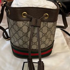 Brand New With Original Dust Bag Authentic Gucci Ophidia Mini Bucket Bag. Dimensions Are 6’w X 7.5’ H X 3.5’ D. Beige And Brown Gg Supreme Canvas. Poshmark Will Authentic Anything Over $500. I Have Original Receipt If Needed. Add This To Your Holiday Attire Or Make It A Gift! Gucci Bucket Bag With Adjustable Strap, Designer Gucci Bucket Bag With Removable Pouch, Gucci Luxury Bucket Bag For Daily Use, Daily Use Gucci Luxury Bucket Bag, Daily Use Luxury Gucci Bucket Bag, Gucci Leather Bucket Bag, Chic Gucci Bucket Bag With Removable Pouch, Gucci Bucket Bag With Removable Pouch, Gucci Luxury Bucket Bag With Removable Pouch