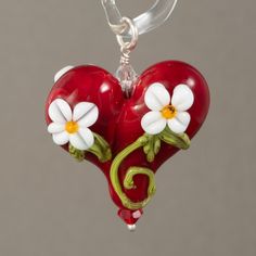 Dark red heart pendant with flowers. Beaded with sterling silver and swarovski crystals. All my beads are properly cleaned They are annealed in a digitally controlled kiln for strength and durability. Each bead is unique Please remember: although every effort is made to create a strong, stable bead, glass is still glass and should be handled with care. The item on the photo is the item sold. I never use stock images or same image for multiple items. We make every effort to provide high quality images to assist you in choosing your item. However, images may vary in color depending on your monitor color settings. If exact color is critical to your order we recommend contacting me by e-mail so I can help you. Thank you for looking at my work Madeleine Ahlström. Whimsical Red Jewelry For Valentine's Day, Whimsical Red Flower Jewelry, Dark Red Heart, Red Heart Pendant, Small Frog, Red Heart, Dark Red, Heart Pendant, High Quality Images