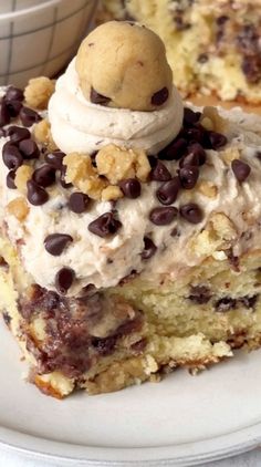 a piece of cake with chocolate chips and ice cream on top is sitting on a plate