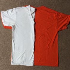 two red and white shirts laying on the floor next to each other, one has an orange stripe