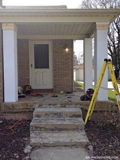 a yellow ladder sitting in front of a house next to a white door and steps