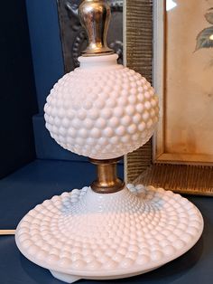 a white vase sitting on top of a table next to a mirror