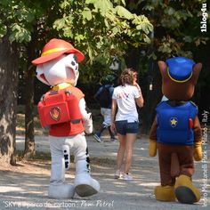 three people in costumes walking down the street with one person dressed as a fireman