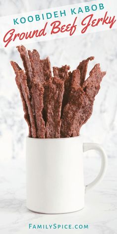 a cup filled with brownies sitting on top of a white counter next to a sign that reads kobodh kabob ground beef gery