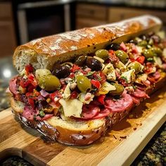 a sandwich with meat and olives on a cutting board