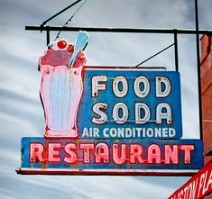 an old neon sign advertising food soda and air conditioning