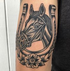 a man's arm with a horse and flowers tattoo design on the left arm