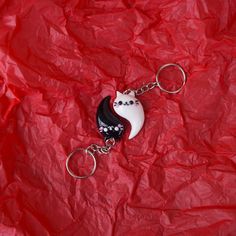 a keychain with a cat on it sitting on a piece of red paper