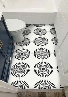 a white toilet sitting next to a bath tub in a bathroom on top of a wooden floor