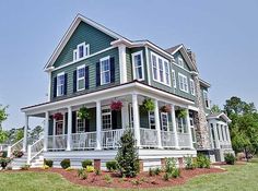 a green house with white balconies on the front and second story is for sale