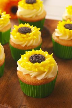 cupcakes with yellow frosting and sunflower decorations on a wooden platter