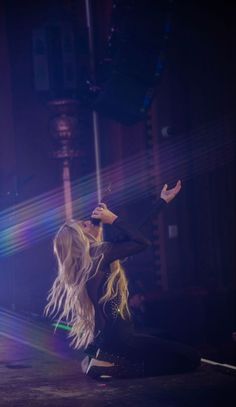 the woman is dancing on stage with her legs spread out