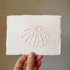 This is an original artwork of a sea urchin, made by puncturing beautiful handmade Khadi paper (640 gsm). The minimal style fits perfectly with this nature inspired subject, and is sure to charm sea lovers everywhere. Although no color is used in this artwork, light and shadow create the shape of this beautiful object.  So far, I have made three of these. All are different - none are perfect. The handmade paper has irregularities and some harder bits of paper pulp make for uneven holes, and litt Sea Urchin Drawing, Sea Line Art, Artwork Light, Khadi Paper, Minimal Artwork, Tactile Art, Nature Inspired Art, Minimal Contemporary, Paper Pulp