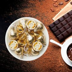 a white plate topped with chocolate covered pastries next to a cup of coffee