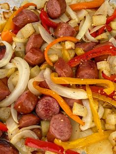 sausages, onions and peppers are mixed together in a dish that is ready to be eaten