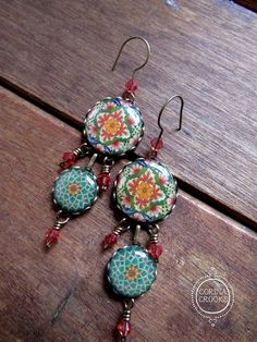 These festive deep green and coral dangle earrings measure approximately 3 inches or 7.5cm. They are handcrafted miniature cabochons of vintage and antique Mexican pottery patterns, sitting in antique brass bezels which ascend in size. The cab tile itself is round and is made from thick, lightweight plastic and multiple layers of glassy resin. The result is a gem like tile that resembles a ceramic piece, minus the weight, the dust, and the lead of ceramic. My tile cabochons are one of a kind and Round Bead Earrings, Bohemian Jewelry Earrings, Vintage Mexican Jewelry, Jewelry Mexican, Pottery Patterns, Pottery Design, Mexican Earrings, Festival Earrings, Walmart Jewelry