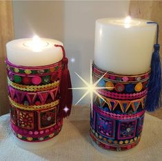 two white candles sitting next to each other on a table