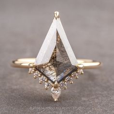 a gold ring with a triangle shaped diamond