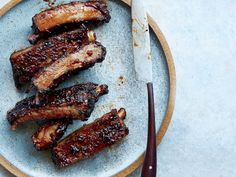 grilled meat on a plate with a knife and fork