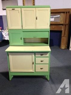 a green and white hutch sitting on top of a carpeted floor