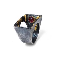 "This oxidized sterling silver and 22K gold ring features a garnet set in an 18K gold bezel. This statement ring is guaranteed to instantly grab the attention of everyone around. Wear it with your favorite jeans for an urban Sunday in town, or pair it with your little black dress for a sophisticated night out.  Upgrade your jewelry collection or gift it to your favorite person!  🔶 Materials ▫️ Oxidized sterling silver   ▫️ 22K gold embellishments  ▫️ A garnet cabochon ▫️ 18K gold bezel 🔶 Dimensions ▫️ Width (top): 0.57\" (14.5 mm) ▫️ Available ring sizes: 5-11 US, 1/4 size increments  🔶 Inspiration  This ring was inspired by volcanoes. It depicts how the burning lava is bursting from inside the mountain.  I think that lava is one of the prettiest things in the world. Pretty and dangerou Mixed Metal Ring, Mixed Metal Rings, Urban Jewelry, Artisan Rings, Active Volcano, Jewelry Metal, Earrings Geometric, Gold Geometric, Black Earrings