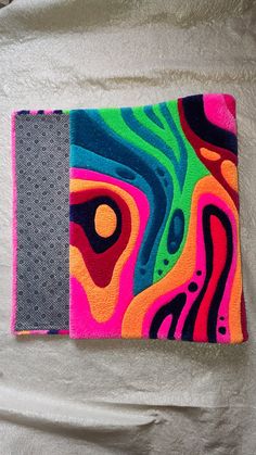 a colorful wallet sitting on top of a white blanket