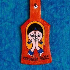 a wooden ornament with a woman's face painted on it