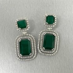 The Renee Emerald & Diamond Earrings are a unique and luxurious heritage pair with royal green emeralds and diamonds set in white gold. Gemstones Type: EmeraldGemstones Shape: RectangularGemstones Weight: 25.01 ctGemstones Color: Green Diamonds Shapes: Round & Marquise Total Diamonds Weight: 3.01 ctDiamonds Color: H - J Diamonds Clarity: VS - SI (Very Slightly Included - Slightly Included) Metal: 14K Gold Metal Wt: 17.4 gms Setting: Prong Set Price Quoted may be negotiable. Please contact us to Green Diamond Earrings With 17 Jewels For Formal Events, Green Diamond Earrings With 17 Jewels For Formal Occasions, Luxury Green Diamond Earrings, Luxury Green Diamond Earrings With Prong Setting, Luxury Green Emerald Diamond Earrings, Luxury Emerald Diamond Earrings, Luxury Green Diamond Earrings With Accents, Green Hand Set Diamond Earrings, Green Hand-set Diamond Earrings