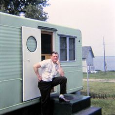 a man sitting on the steps of an old trailer