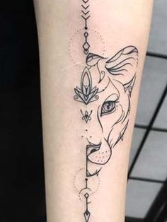 a woman's arm with a dog and arrow tattoo on the left inner forearm