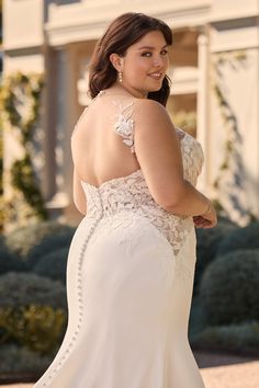 a woman in a wedding dress is posing for the camera with her back to the camera