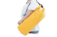 a woman carrying a large yellow duffel bag