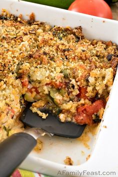 a casserole dish with tomatoes, zucchini and bread crumbs